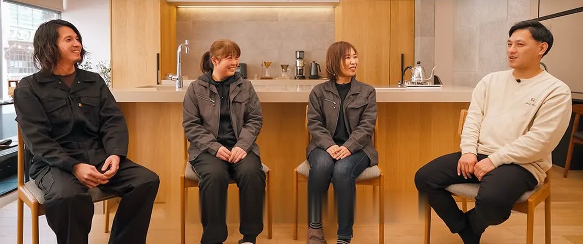 株式会社田中工藝様の社員4名が、キッチンのショールームで話しているところ